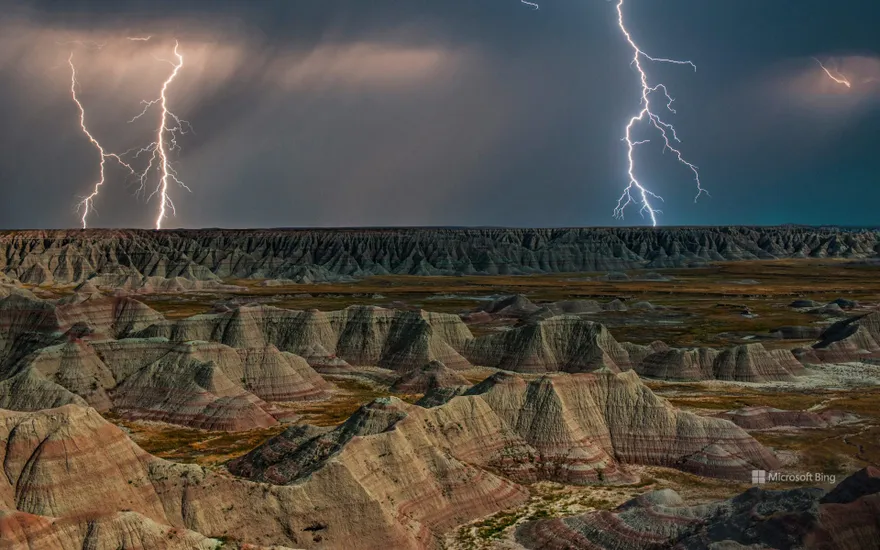 Rock formations in Badlands National Park during a lightning storm, South Dakota, USA