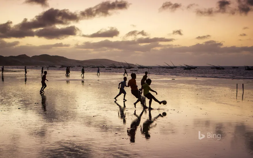 Young boys playing soccer on a beach in Ceará state, Brazil