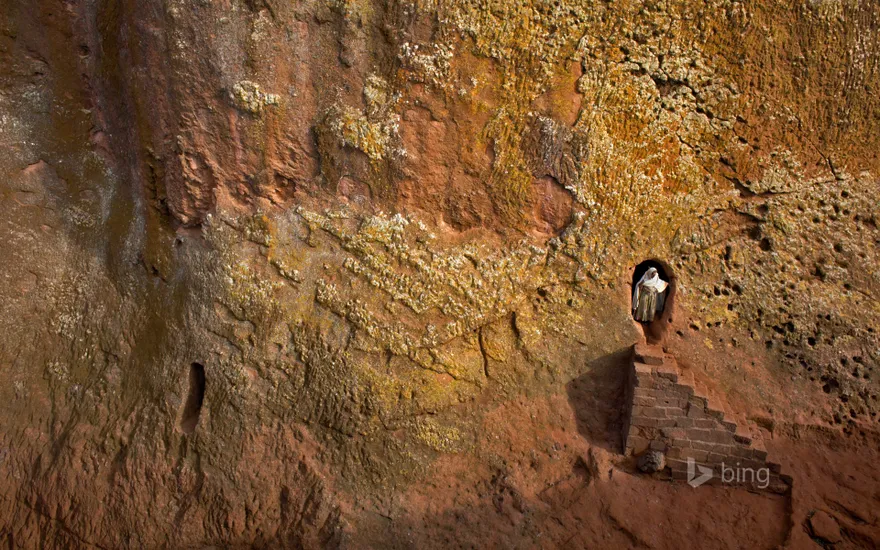 Woman emerges from a tunnel leading to Bet Amanuel, in Lalibela, Ethiopia