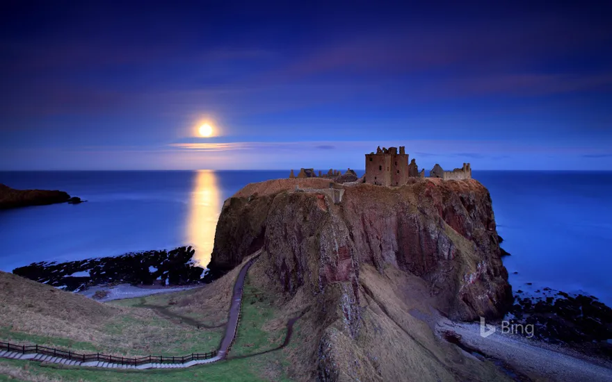 Full moon rising over Dunnottar Castle near Stonehaven on the northeast coast of Scotland