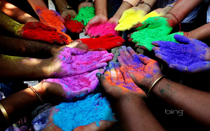 People holding colored powders to celebrate Holi (Festival of Colors) in Ahmedabad, India