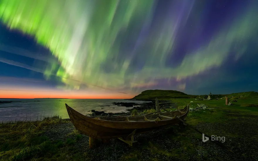 The northern lights over a rowboat in Norstead Viking Village, Newfoundland, Canada