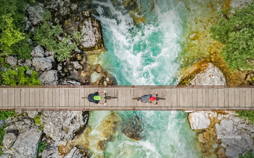 Cyclists on a wooden bridge over the river Soča, Triglav National Park, Slovenia