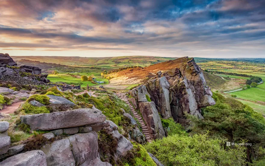 View of the rocky gritstone edge of The Roaches looking over the patchwork landscape, Peak District, Staffordshire.