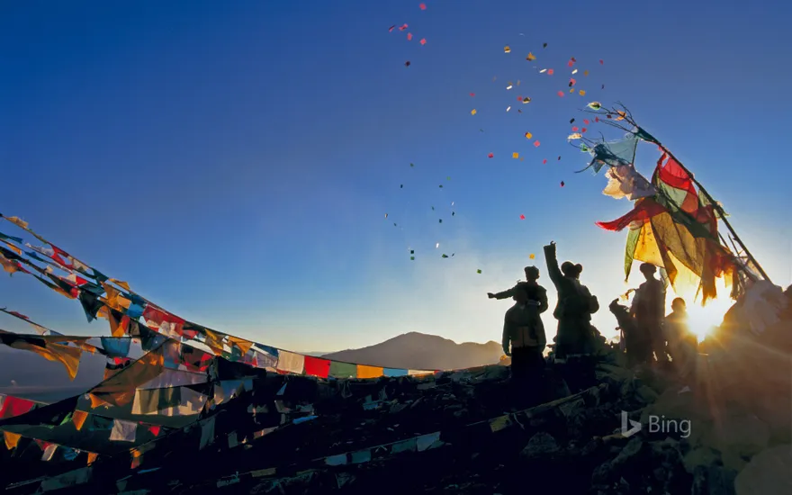 Pilgrims throwing wind horses into the air above Ganden Monastery for the New Year in Tibet, China